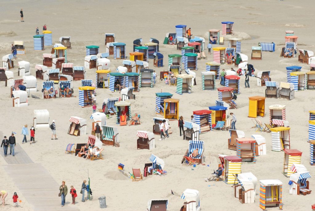 Zdjęcie, kolorowe parawany na plaży.